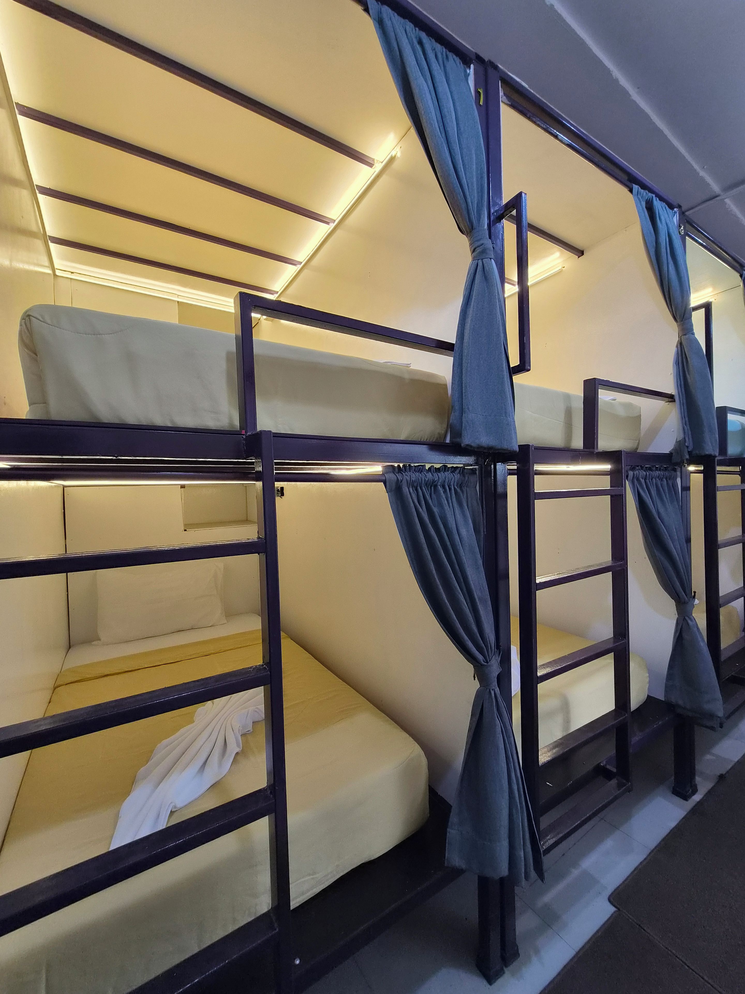 A bunk bed room with curtains tied at the head of each bed.