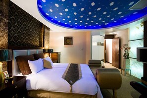 A modern hotel room with a large bed, a desk, and a seating area. - Crystal Motel (Hsinchu)