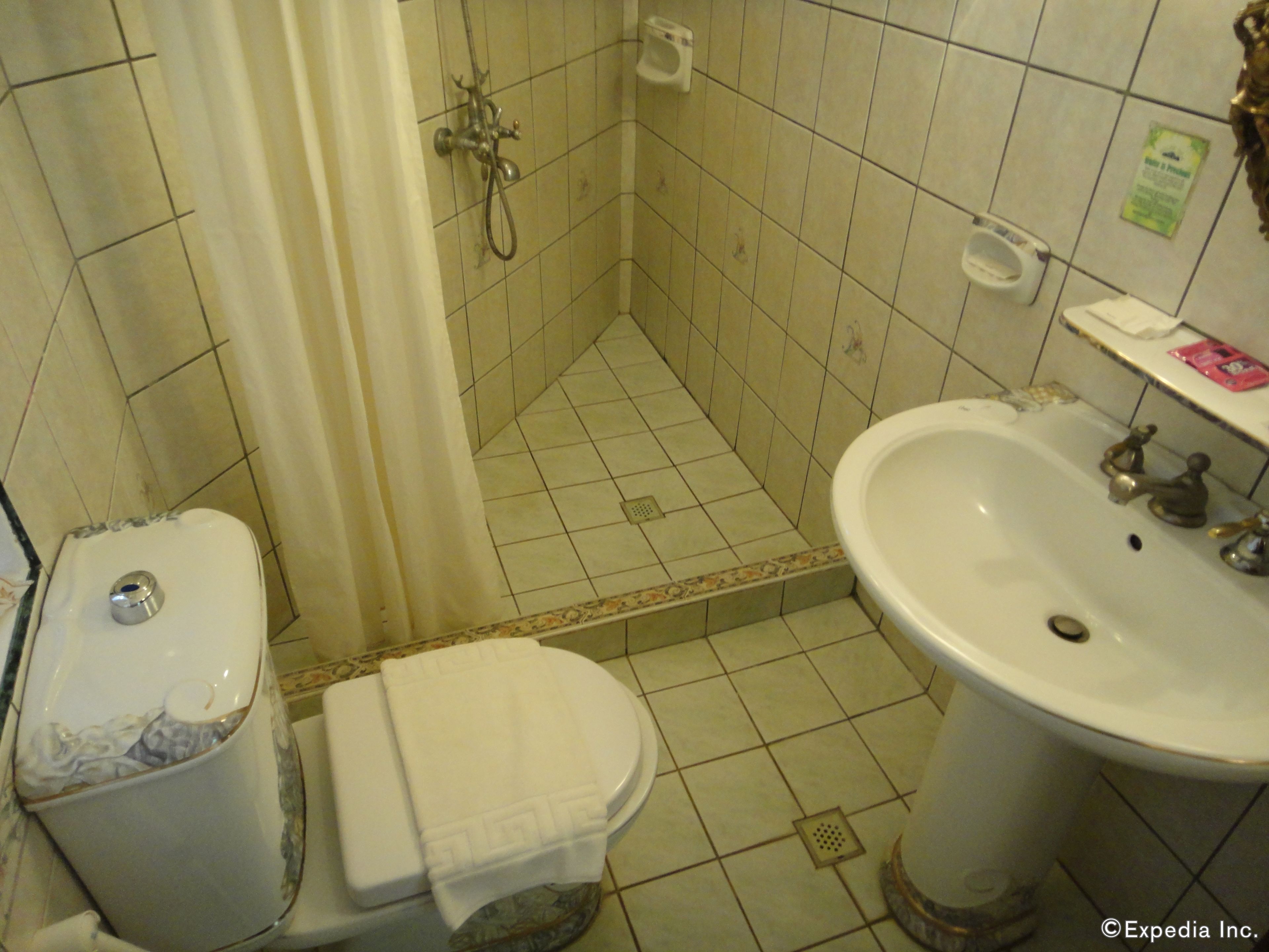 Ett badrum med toalett, handfat och dusch.