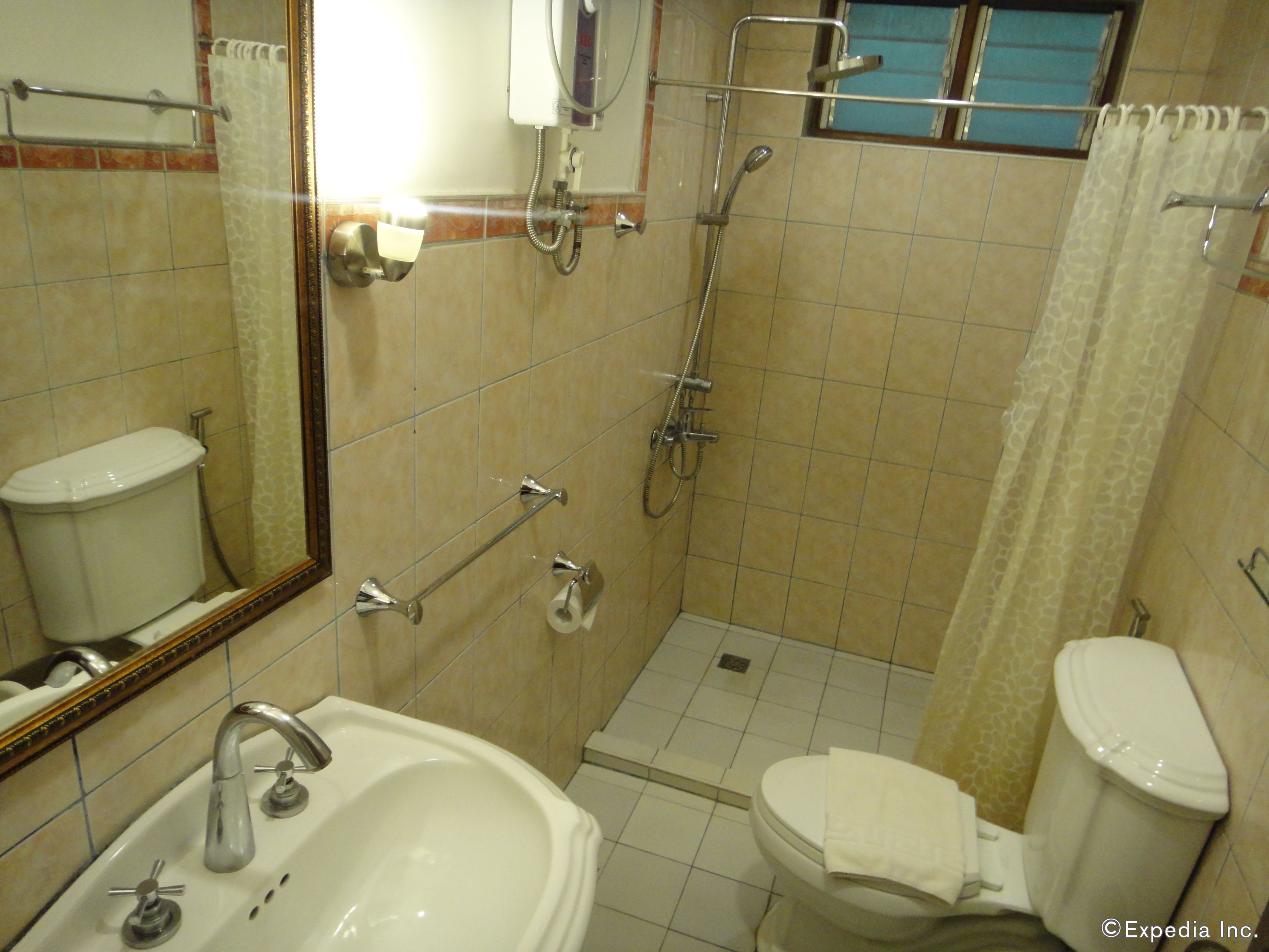 Un baño con lavamanos, inodoro y ducha.