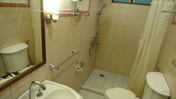 Un baño con lavamanos, inodoro y ducha.