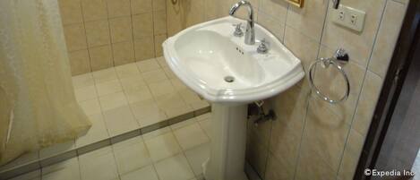 Un baño con lavabo, espejo y ducha.