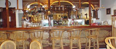 A bar area with wooden chairs and a bar counter.