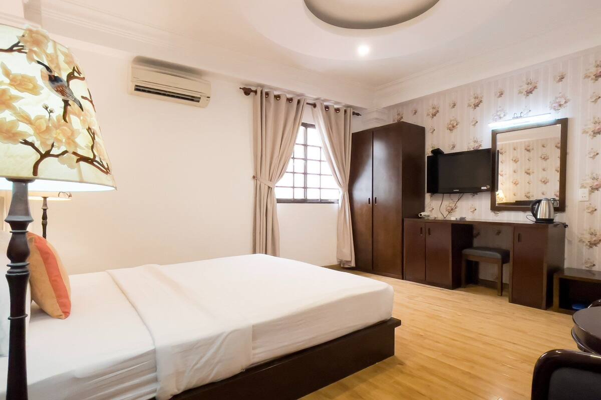 Une chambre d’hôtel équipée d’un lit, d’un bureau, d’une chaise, d’une télévision et d’une armoire.