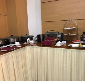 A breakfast buffet setup with various food items and cooking appliances. - Little Brick Saigon Hotel (Ho Chi Minh City)