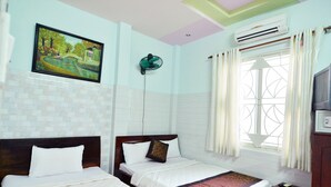 A hotel room with two beds, a painting on the wall, an air conditioner, and a window with curtains. - Lamenda Saigon Hotel (Ho Chi Minh City)