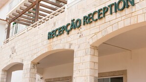 A reception area with a sign that reads "RECEPCAO RECEPTION" on a building facade.