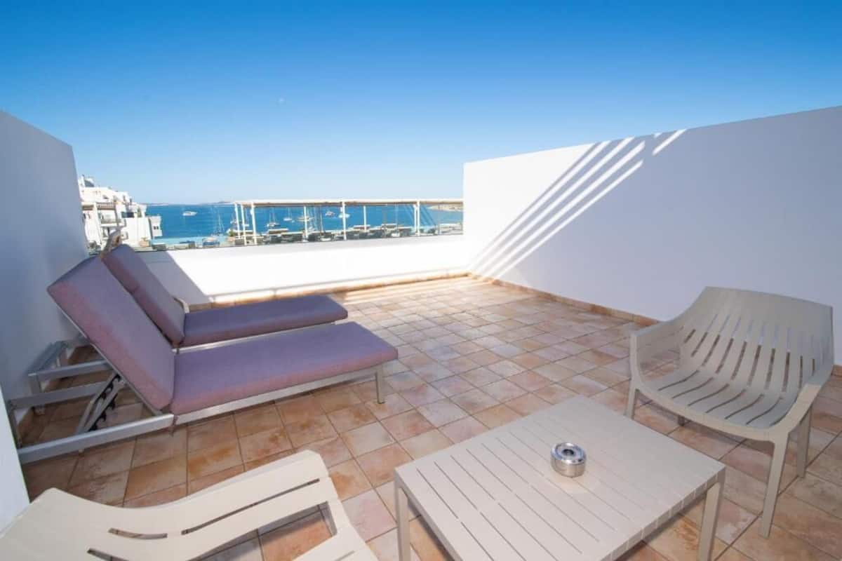 Terraza en la azotea con mesa de billar, sillones de descanso y vistas al mar.