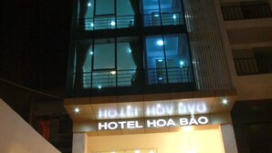 Une enseigne d’hôtel avec le nom « HÔTEL HOA BÃO » écrit en lettres lumineuses.