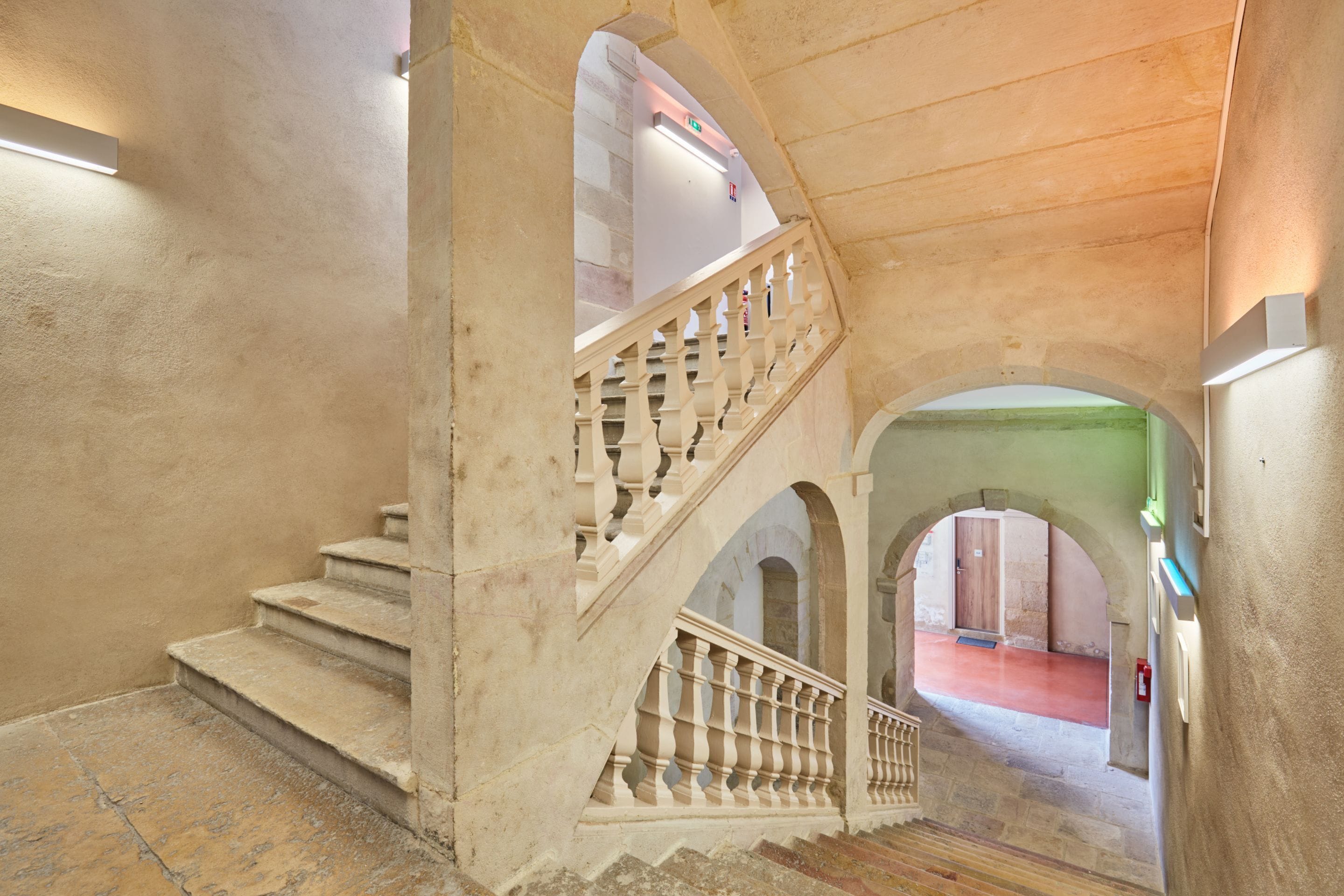 Un grand escalier orné d’une balustrade, menant à un niveau supérieur.