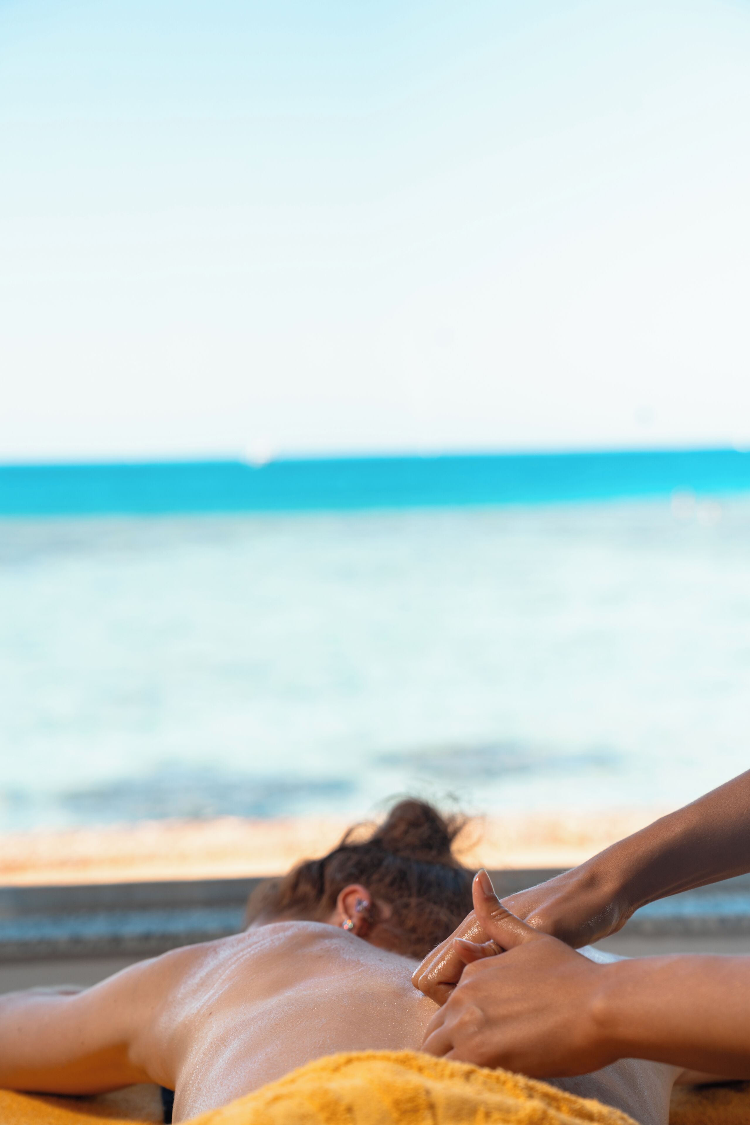 Eine Person bekommt am Meer eine Massage.