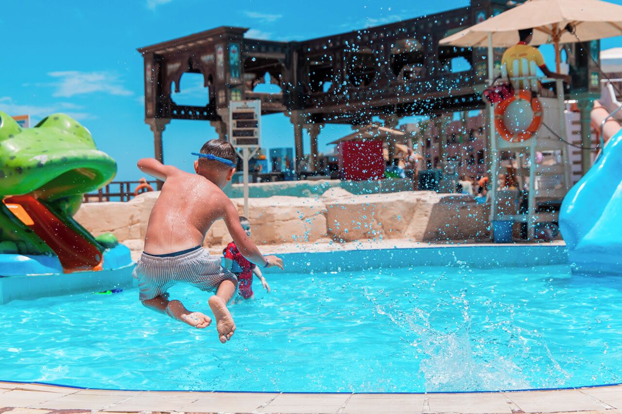 A swimming pool with a water slide and a lifebuoy.