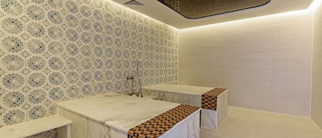 A bathroom with patterned wallpaper, marble countertops, and a starry ceiling design.