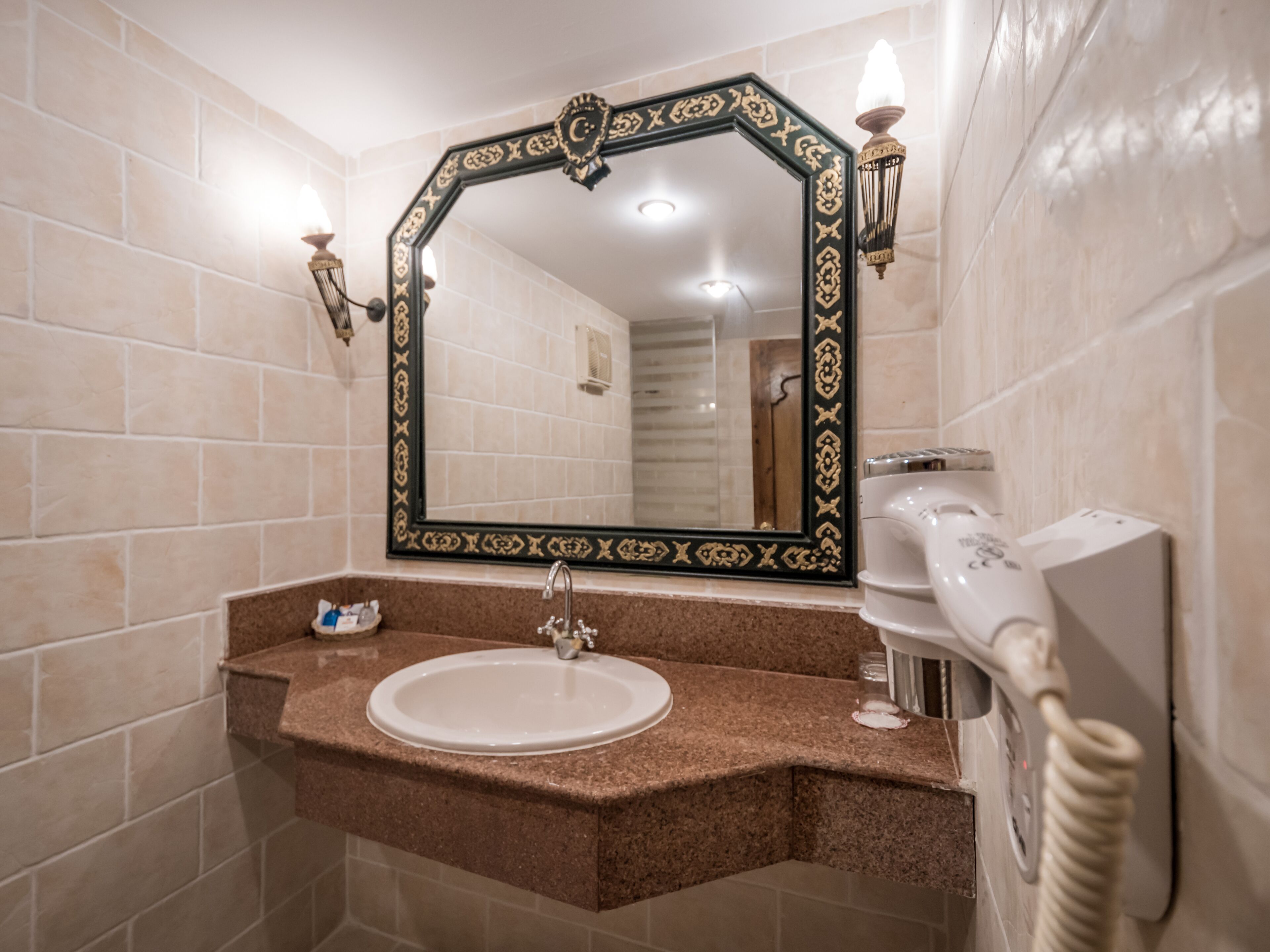 Un bagno con un grande specchio, un lavandino e un asciugamano riscaldato.