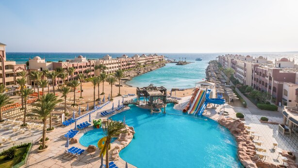 A resort with a swimming pool, palm trees, and a view of the sea. - Sunny Days El Palacio Resort & Spa - All inclusive (Hurghada)