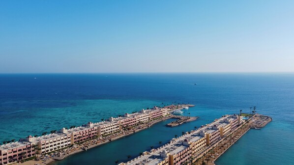 Un hôtel en bord de mer composé de plusieurs bâtiments, doté d’un port de plaisance et offrant une vue dégagée sur la mer.