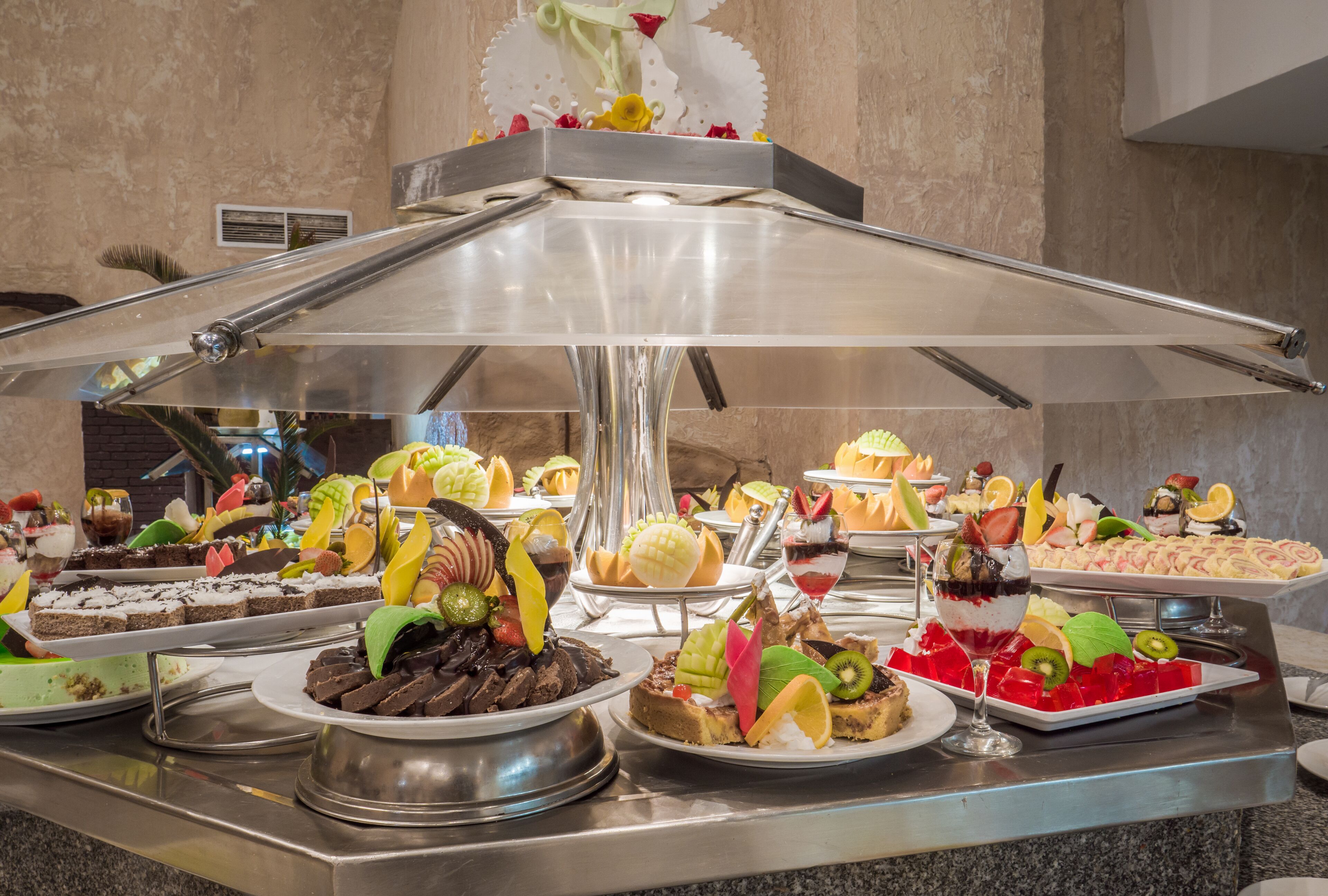 A buffet with various desserts and fruits.