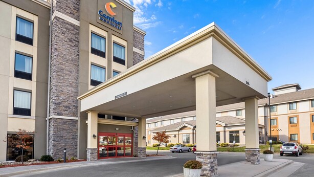 A Comfort Inn hotel with a stone facade, a covered entrance, and a parking area. - Comfort Inn & Suites West - Medical Center (Rochester)