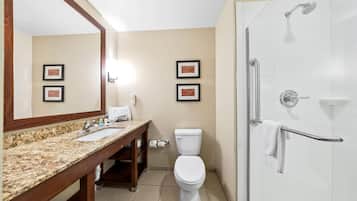 Un baño con lavamanos, inodoro y ducha a ras de suelo de mármol.