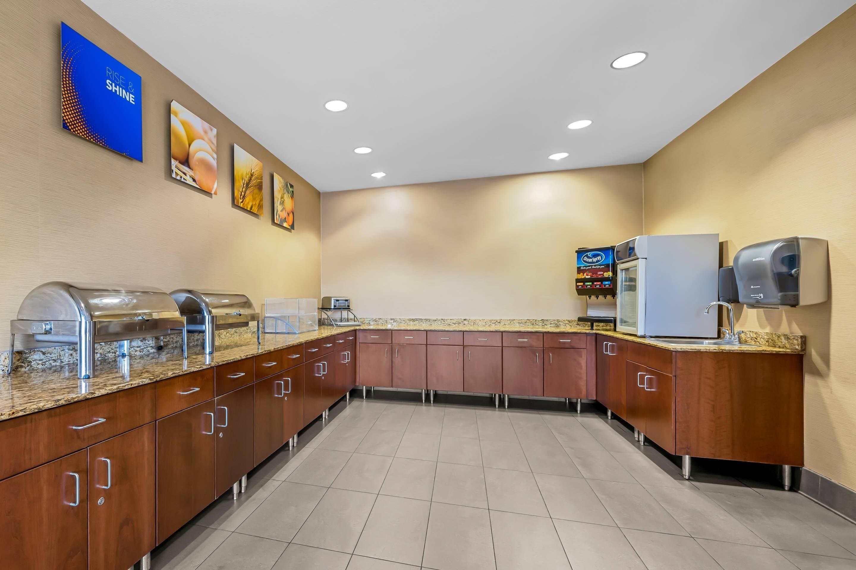 Una cocina moderna con electrodomésticos de acero inoxidable, armarios de madera y una encimera de granito.
