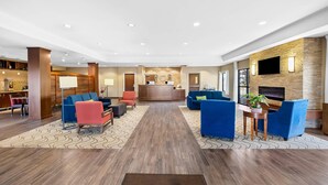 A spacious lobby with a central seating area, a reception desk, and a fireplace. - Comfort Inn & Suites West - Medical Center (Rochester)