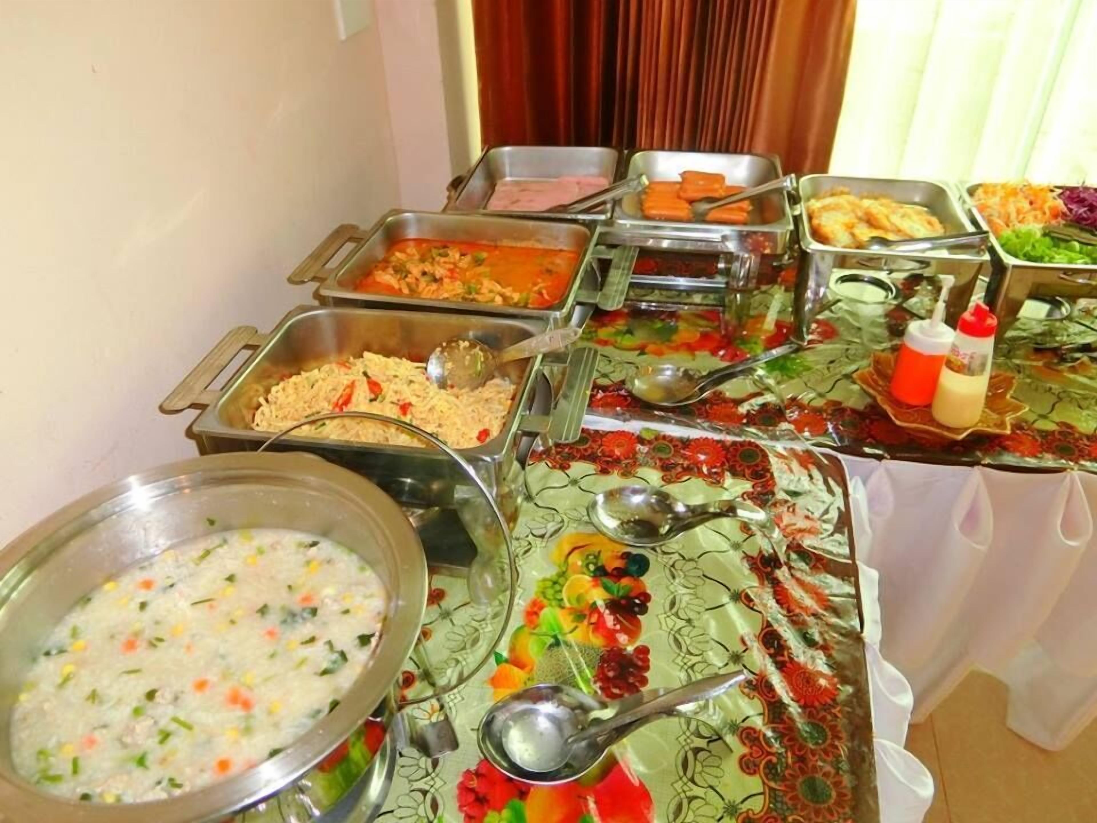 A buffet table with various food items and serving utensils.