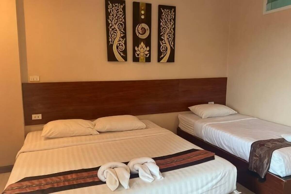 A hotel room with two beds, a wooden headboard, and three wall-mounted artworks.