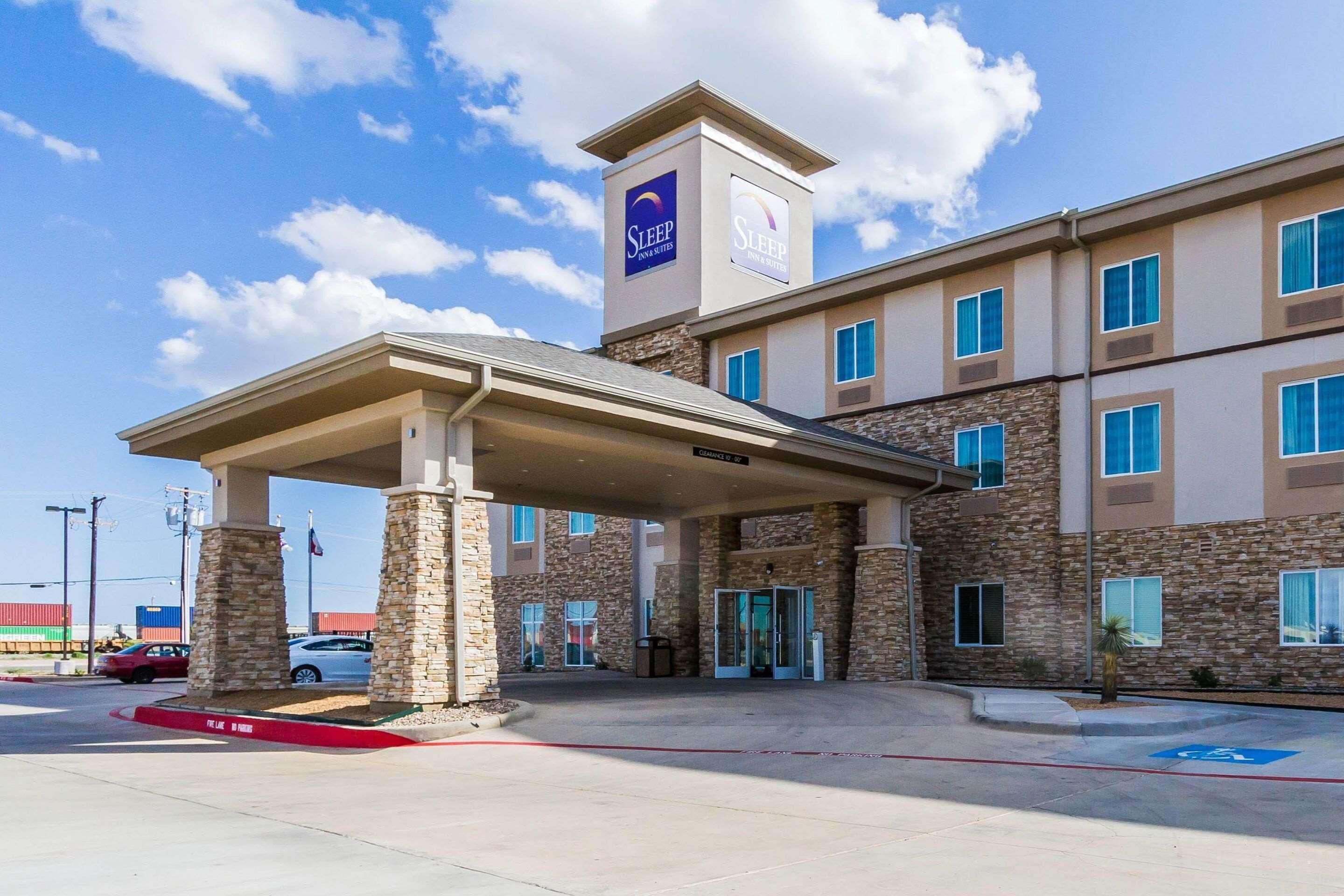 A hotel with a covered entrance, stone facade, and multiple windows.