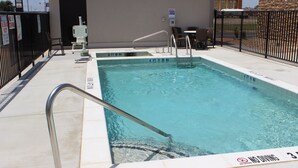 A swimming pool with a no diving sign, a metal handrail, and a chair. - Spark by Hilton Odessa (Odessa)