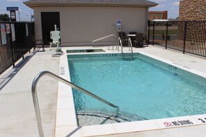 A swimming pool with a no diving sign, a metal handrail, and a chair. - Sleep Inn And Suites (Odessa)