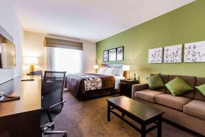 A hotel room with a bed, a sofa, a desk, a chair, and artwork on the walls. - Spark by Hilton Odessa (Odessa)
