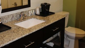 A bathroom with a sink, mirror, towel rack, and a toilet. - Spark by Hilton Odessa (Odessa)