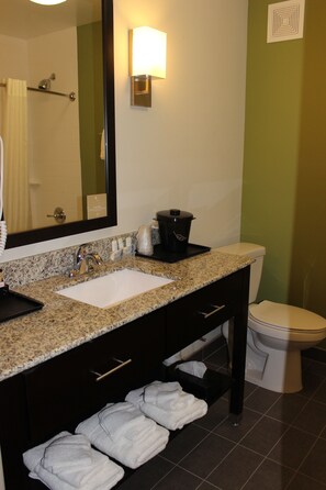 A bathroom with a sink, mirror, towel rack, and a toilet. - Sleep Inn And Suites (Odessa)
