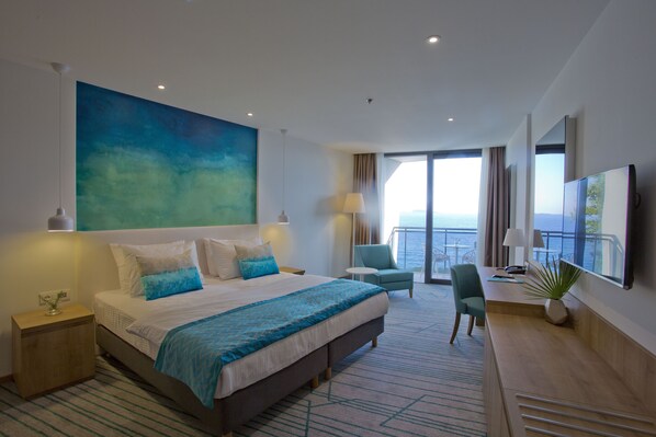 A modern hotel room with a large bed, a desk, and a balcony with a view. - Maistra Select Mlini Hotel (Zupa dubrovacka)