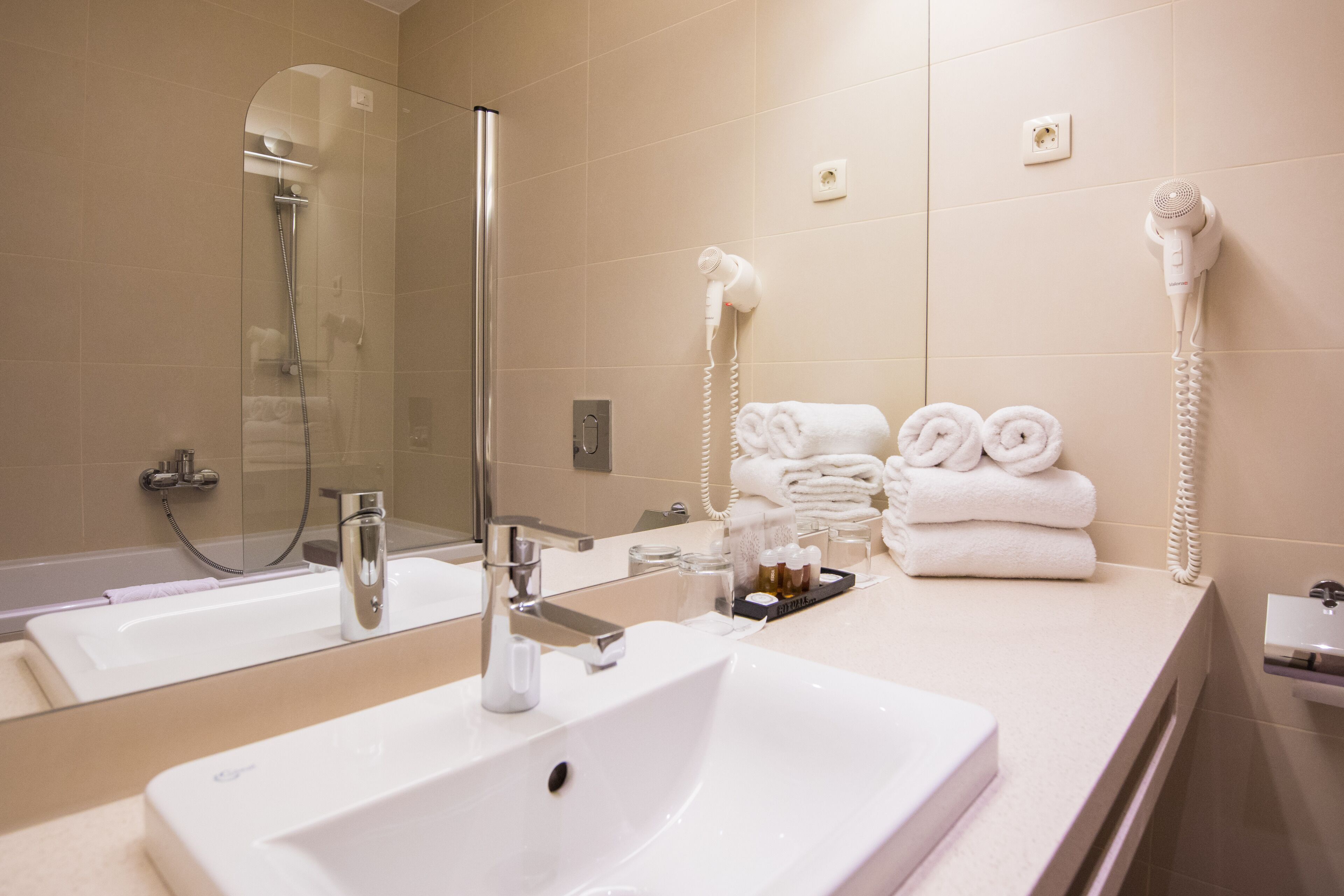 designer toiletries, hair dryer, slippers, towels