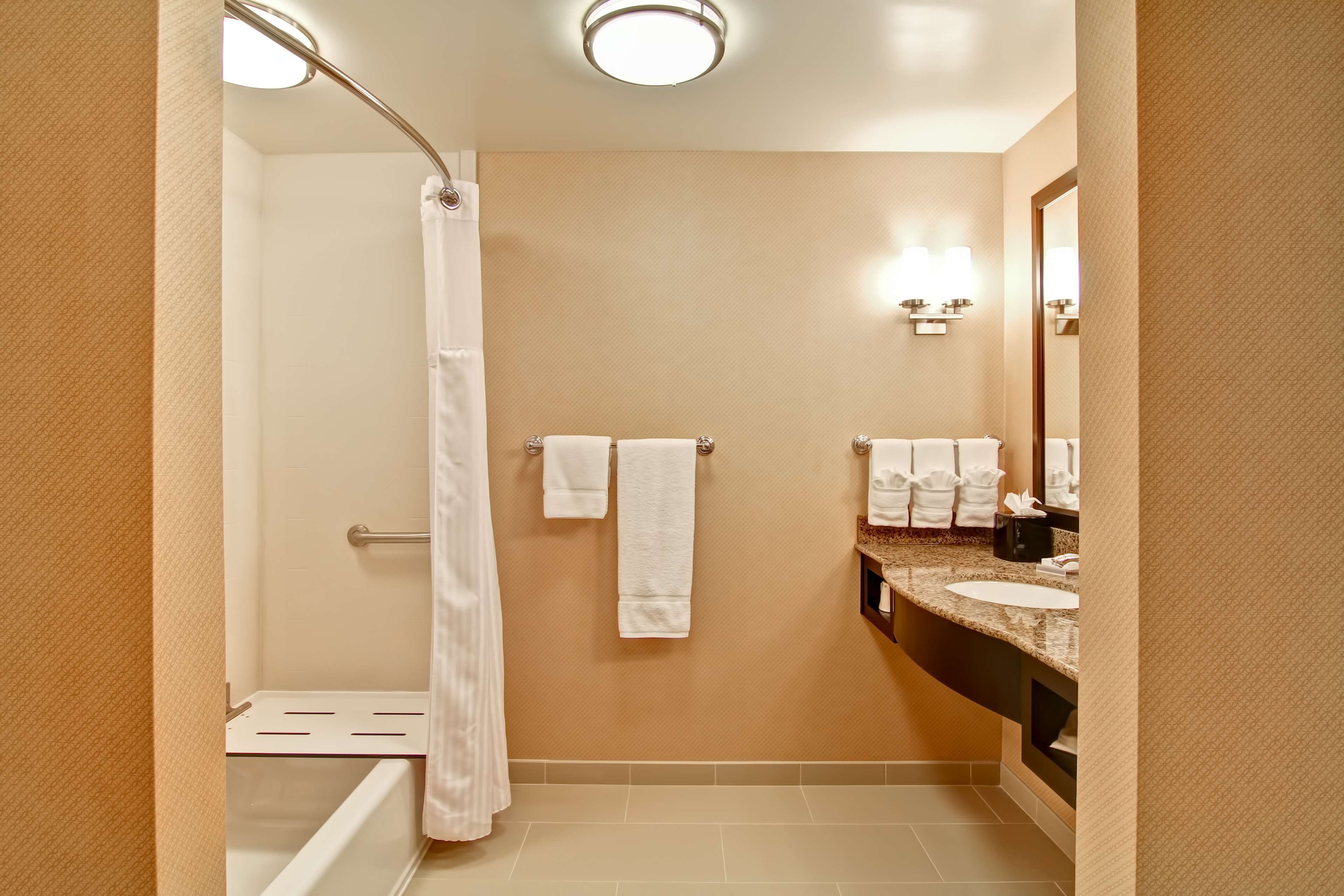 Une salle de bain équipée d’une douche, de toilettes, d’un lavabo et d’un miroir.