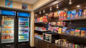 Un espace de libre-service où l’on peut trouver des aliments, avec des congélateurs réfrigérés et des étagères remplies de collations et de boissons.