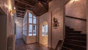A hallway with a wooden staircase, a radiator, and a decorative wall piece. - Boutique Residence by Little King (Prague)