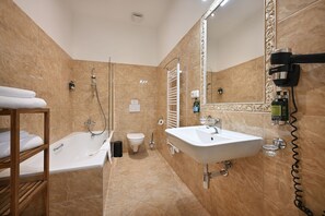 A modern bathroom with a bathtub, a sink, a toilet, and a large mirror. - Boutique Residence by Little King (Prague)