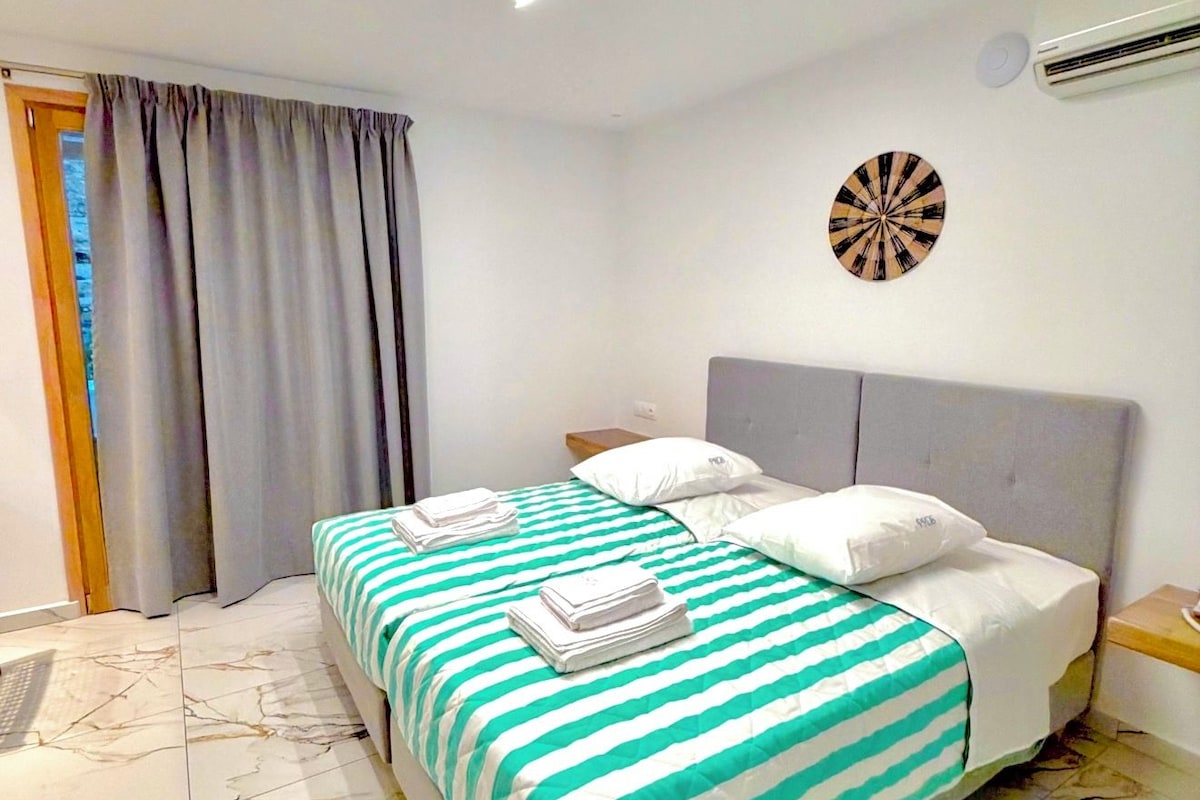 A hotel room with a bed, a dartboard, and a window with curtains.