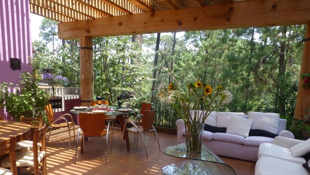 An outdoor patio with a dining table, chairs, a sofa, and a glass coffee table. - La Casa del Rio (Valle de Bravo)
