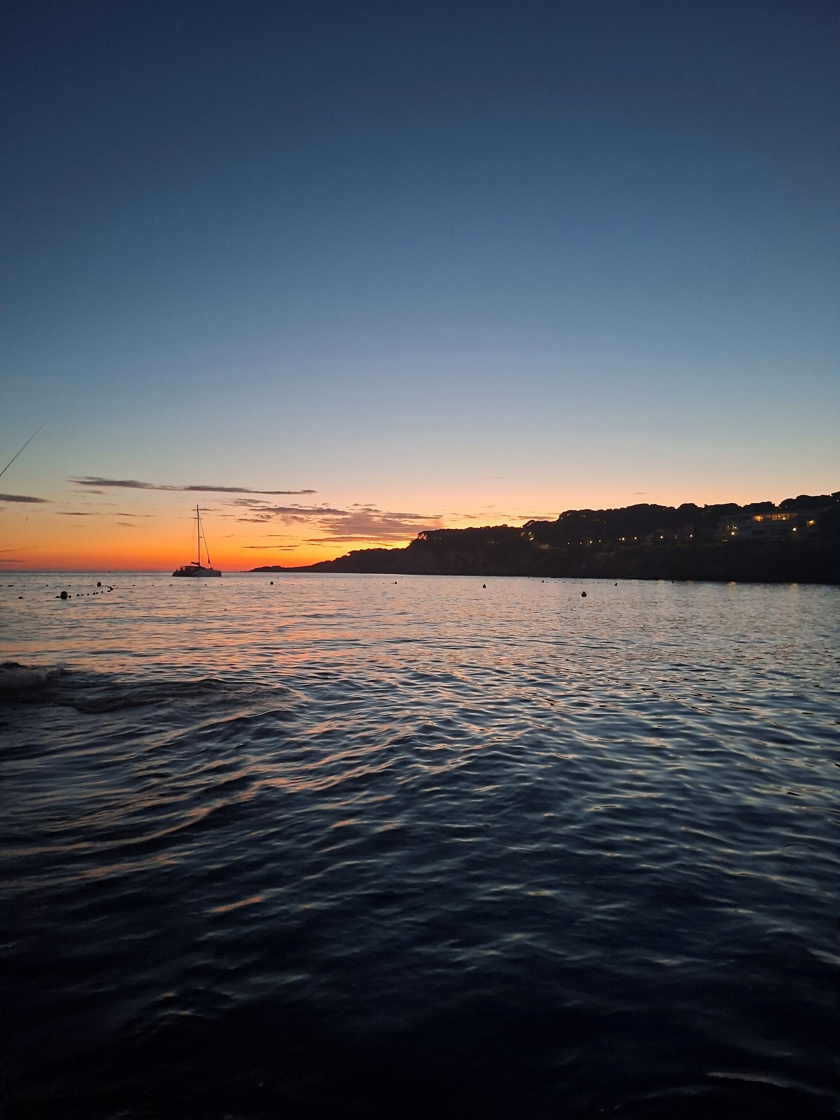 A coastal scene with calm waters and a distant shoreline.