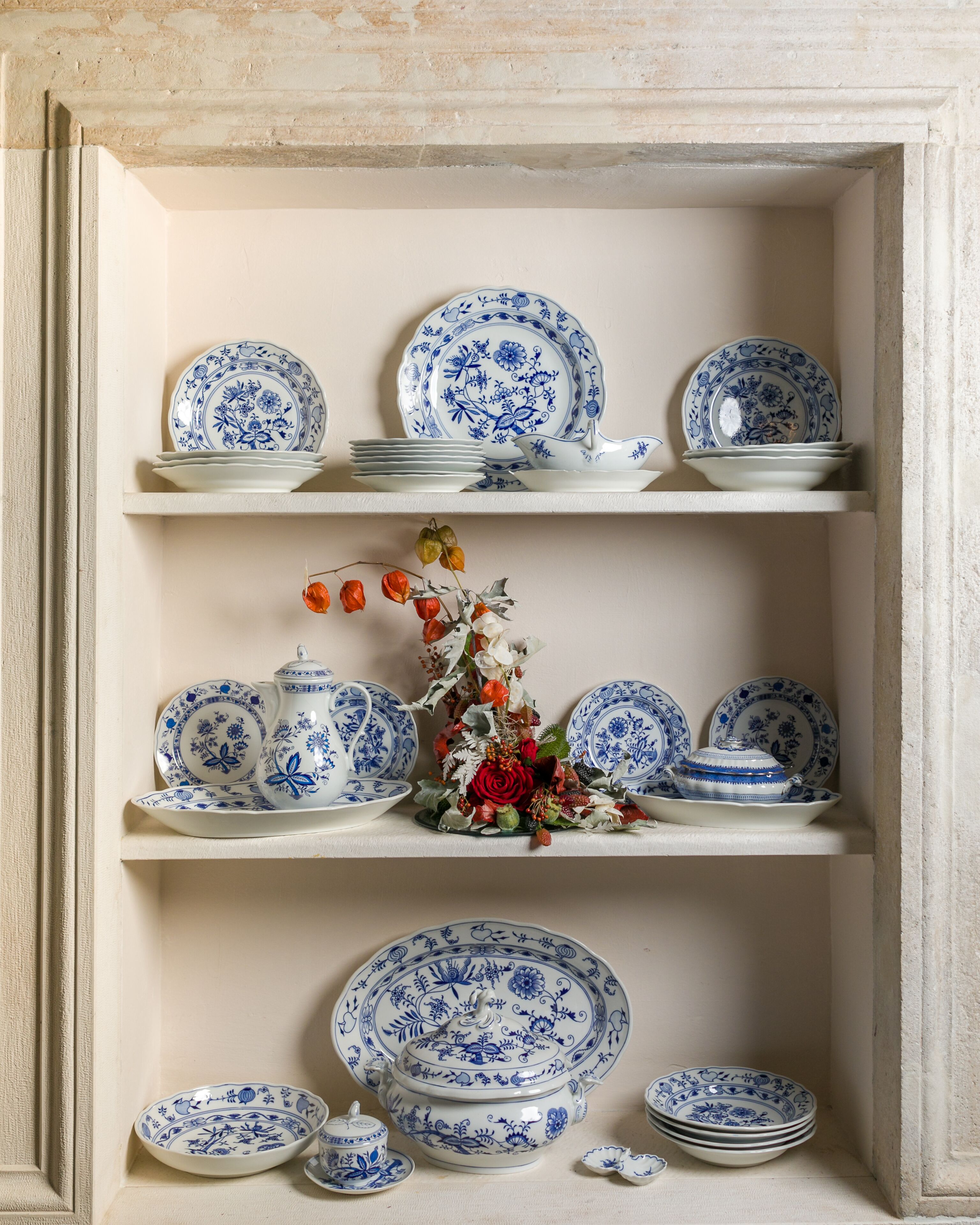 A display of blue and white porcelain plates and bowls on shelves.