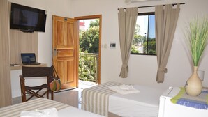 A hotel room with two beds, a desk with a laptop, a TV mounted on the wall, and a balcony with curtains. - Hotel Salzburgo (Presidente Franco)