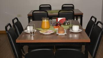A dining table set with plates of food, a pitcher of orange juice, and various condiments.