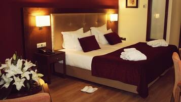 Relax in comfort with a large bed featuring a tufted headboard, complete with crisp linens and plush throw pillows.