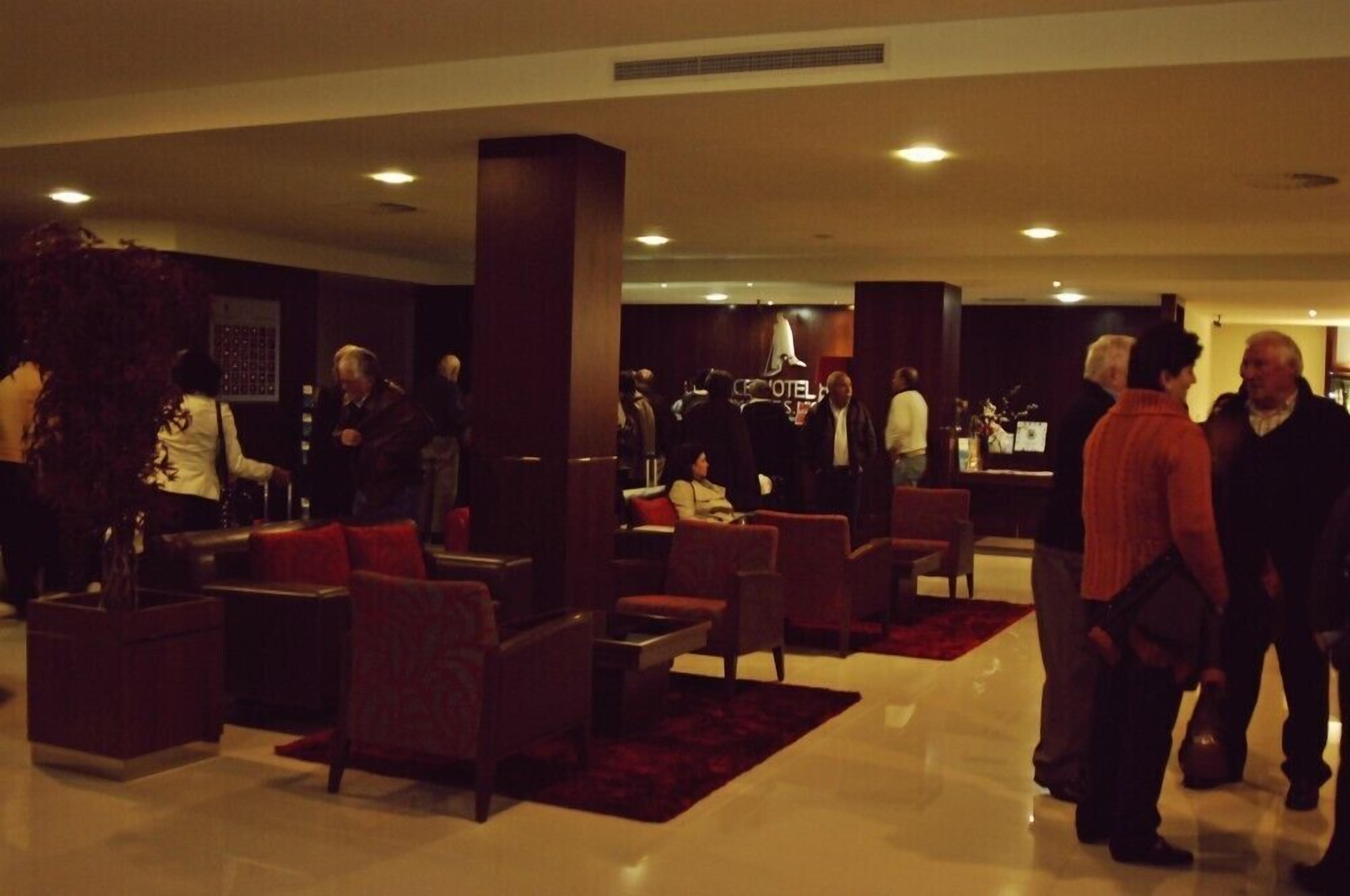 A lobby with seating areas, a reception desk, and a large plant.