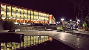 A hotel with a modern design, featuring a large parking area and a water feature in the foreground. - Palace Hotel & Spa Termas de S. Miguel (Fornos de Algodres)