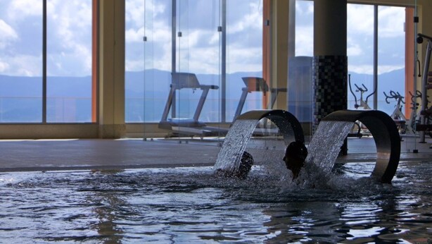 An indoor swimming pool with clear views of mountains through large windows. - Palace Hotel & Spa Termas de S. Miguel (Fornos de Algodres)