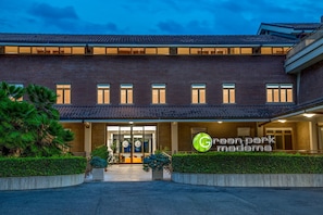 A modern building with a brick facade, large windows, and a sign reading "Green Park Madama". - Hotel Green Park Madama Spa & Wellness (Castel Madama)